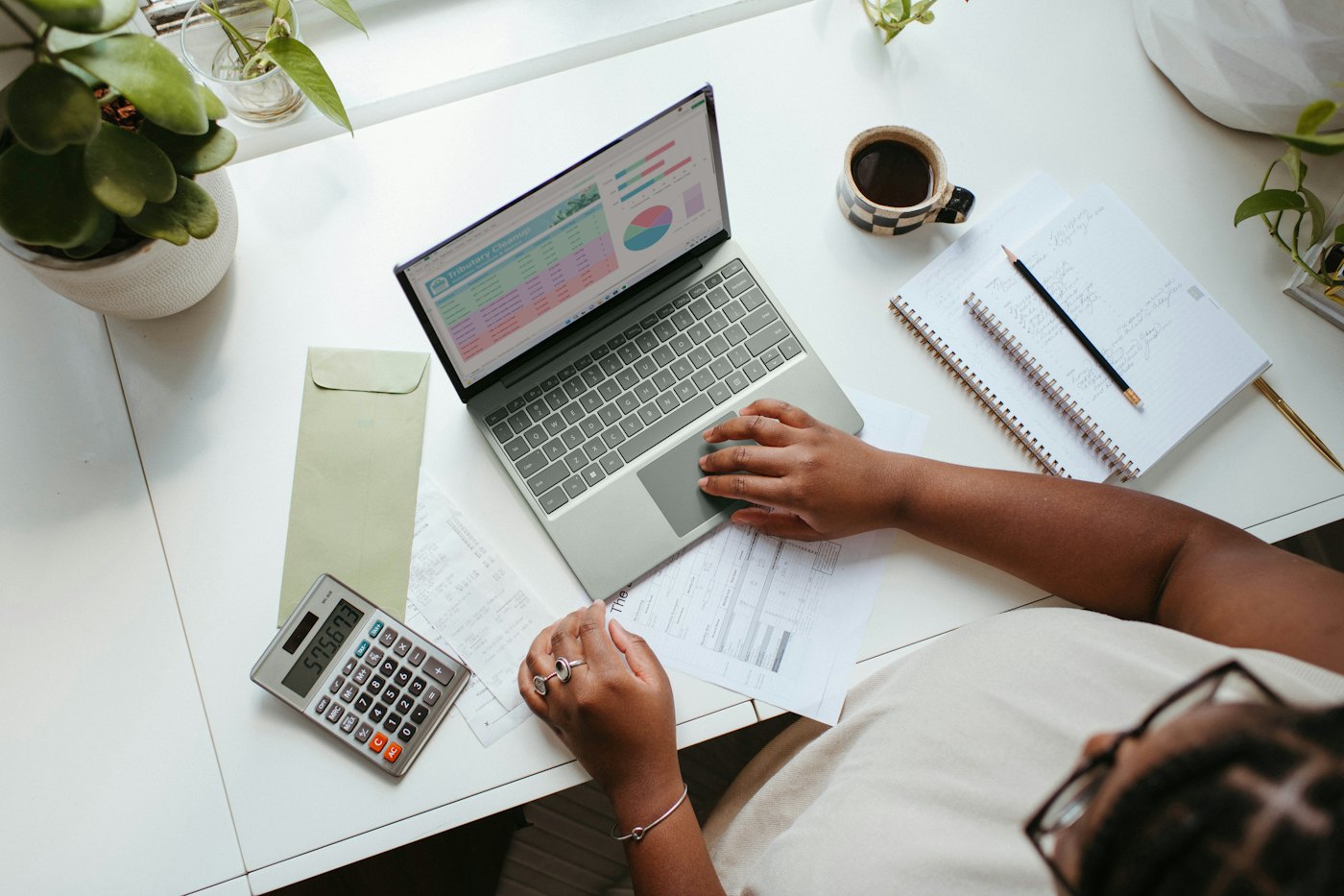 Accountant working with a laptop, calculator and financial reports